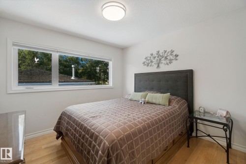 Large window with white trim, light wood-finish flooring, and a flush-mount ceiling light - 12916 63 Street Nw, Edmonton, AB 
