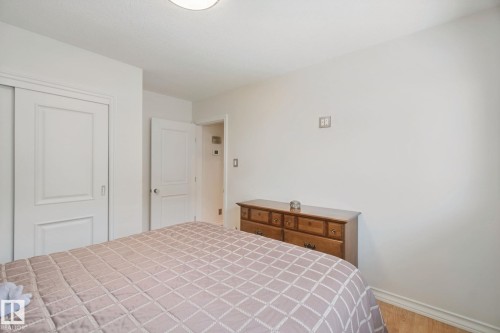 White walls, wood-finish flooring, recessed ceiling light, white paneled interior doors, and white trim - 12916 63 Street Nw, Edmonton, AB 