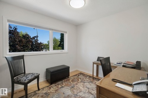 Light wood-finish flooring with white baseboards - 12916 63 Street Nw, Edmonton, AB 