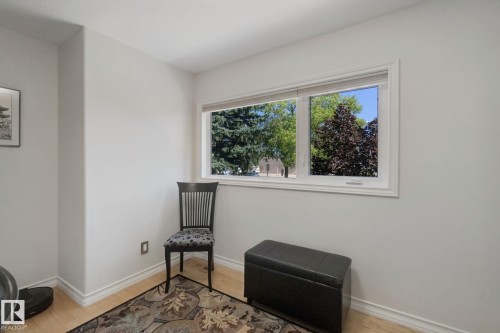 Light wood-finish flooring with white baseboards and a large window with white trim - 12916 63 Street Nw, Edmonton, AB 