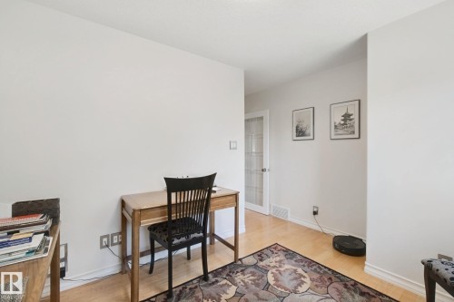 Light wood-finish flooring with white baseboards throughout - 12916 63 Street Nw, Edmonton, AB 