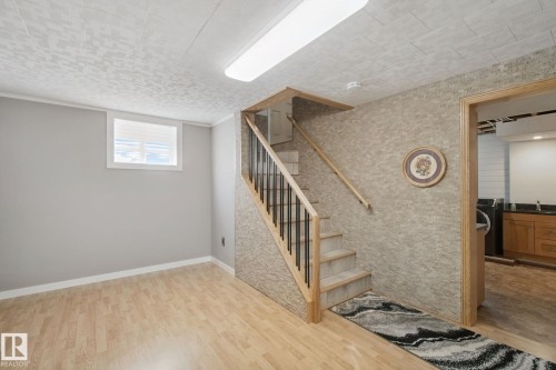 Wood-finish flooring, light grey painted walls, white trim, and a window with white blinds - 12916 63 Street Nw, Edmonton, AB 