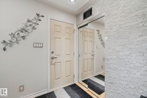 Recessed lighting illuminates the entryway, featuring a paneled door with brushed nickel hardware - 12916 63 Street Nw, Edmonton, AB 