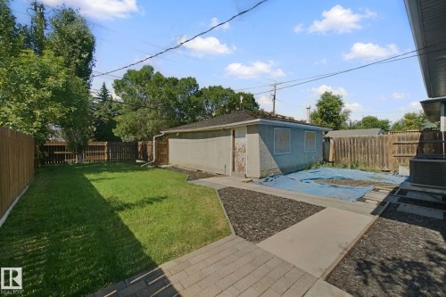 Private backyard featuring a fenced perimeter, a concrete patio, and a manicured lawn - 12916 63 Street Nw, Edmonton, AB 