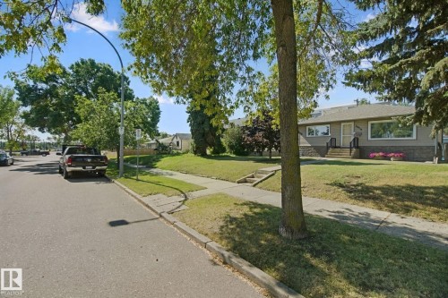 Single-story exterior with stone veneer accents, large picture windows, and a raised front entry - 12916 63 Street Nw, Edmonton, AB 