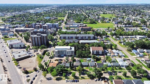 Expansive urban landscape featuring mature trees, diverse residential architecture, multistory commercial buildings, and surface parking areas - 12916 63 Street Nw, Edmonton, AB 