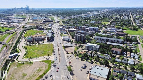 Urban landscape with extensive green spaces, a prominent central thoroughfare, and a distant city skyline - 12916 63 Street Nw, Edmonton, AB 