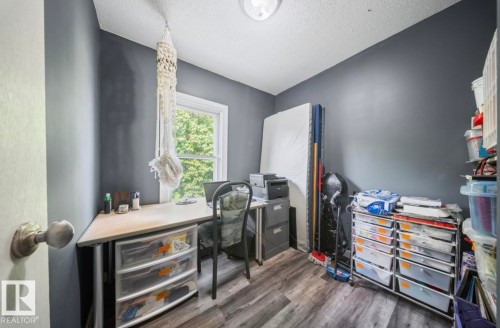 Interior room featuring wood-finish flooring, a window with natural light, and a ceiling light fixture - 12150 47 Street Nw, Edmonton, AB - Indoor