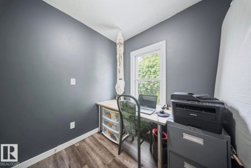 Compact room featuring a single window with white trim, wood-finish flooring, and dark grey wall paint - 12150 47 Street Nw, Edmonton, AB - Indoor