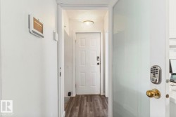 Entryway featuring wood-finish flooring, a white paneled door with a digital keypad lock, and a flush mount ceiling light - 