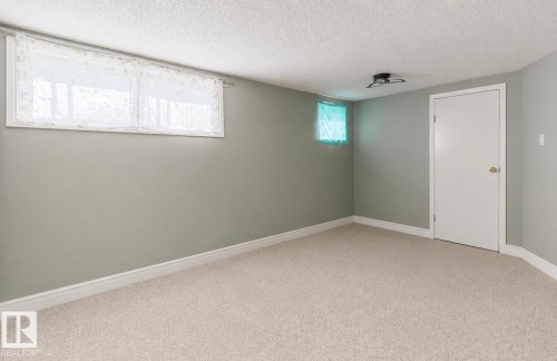 Light grey wall paint with clean white trim - 12150 47 Street Nw, Edmonton, AB - Indoor Photo Showing Other Room