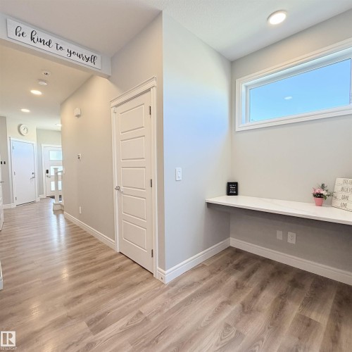 Wood-finish flooring throughout, recessed ceiling lighting, built-in window with white trim, and a built-in white floating desk - 1003 Goldfinch Way Nw, Edmonton, AB 