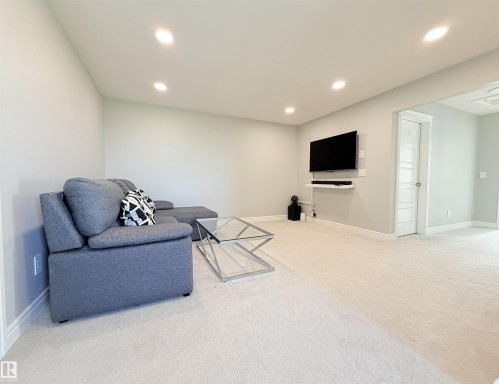 Recessed lighting, wall-mounted television, and light-toned carpeting - 1003 Goldfinch Way Nw, Edmonton, AB 