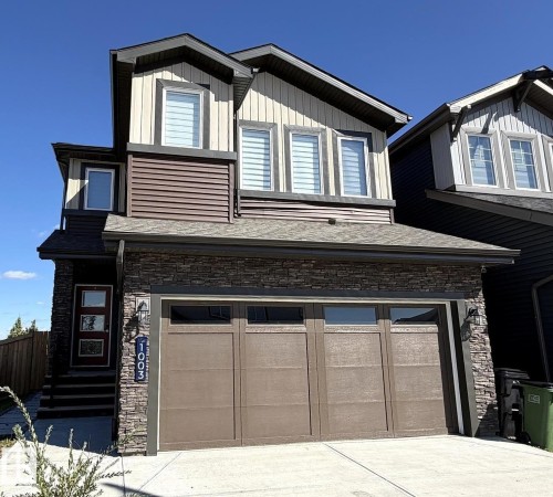 Stone veneer facade, two-car garage, multi-pane windows, and a multi-level roofline - 1003 Goldfinch Way Nw, Edmonton, AB 