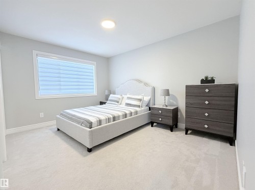 Plush carpet flooring, a large window with blinds, and recessed lighting - 1003 Goldfinch Way Nw, Edmonton, AB 