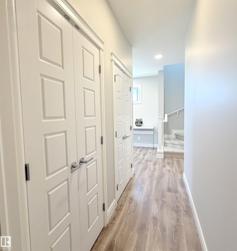 Wood-finish flooring throughout, white paneled doors, recessed lighting, and a window with a built-in bench - 1003 Goldfinch Way Nw, Edmonton, AB 