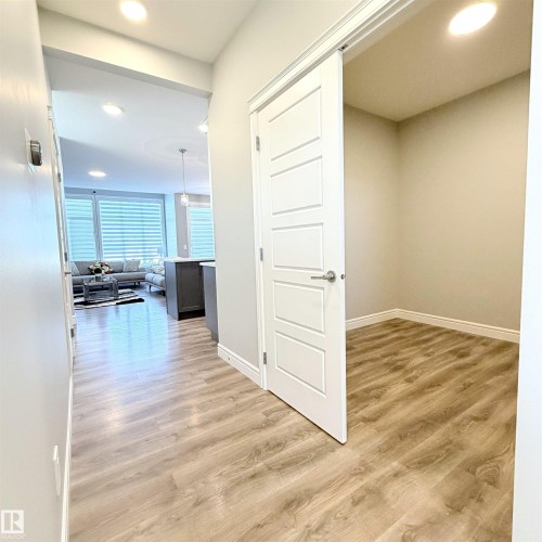 Wood-finish flooring throughout, recessed lighting, white interior doors, and neutral wall tones - 1003 Goldfinch Way Nw, Edmonton, AB 