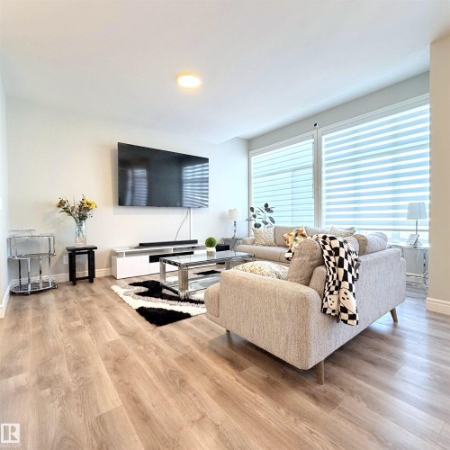 Recessed ceiling lighting, wood-finish flooring, and expansive windows with dual-layer blinds - 1003 Goldfinch Way Nw, Edmonton, AB 
