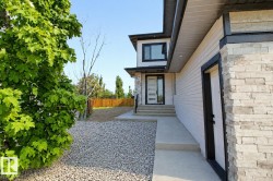 Modern exterior featuring light-colored siding, black trim, and stone veneer accents - 