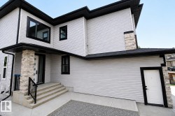 Modern exterior showcasing light-toned siding, black-framed windows, and stone accents - 
