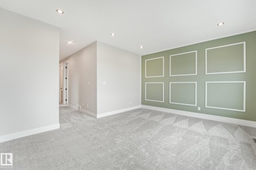 Recessed lighting, patterned carpeting, decorative wall molding, and white trim - 16 Middleton Close, Leduc, AB 