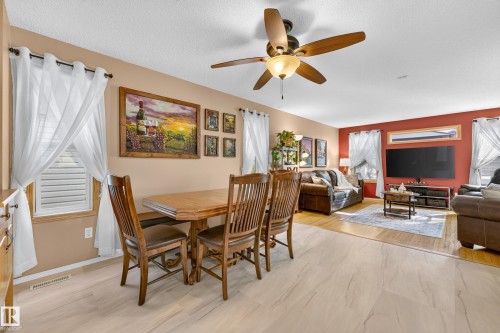 Dining area with tiled flooring, leading to a living area with wood flooring - 1223 Gillespie Crescent Nw, Edmonton, AB 