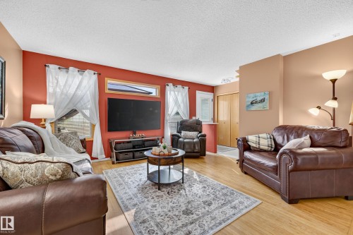 Wood-finish flooring throughout, complemented by a vibrant accent wall - 1223 Gillespie Crescent Nw, Edmonton, AB 