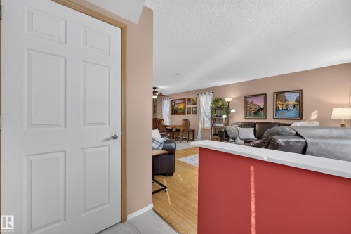 Wood-finish flooring throughout, featuring a white paneled interior door and a partial wall with a white cap - 1223 Gillespie Crescent Nw, Edmonton, AB 