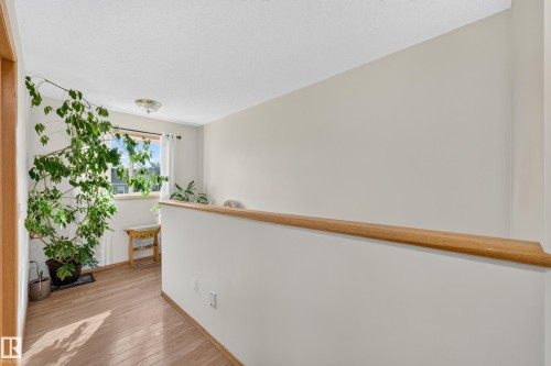 Wood-finish flooring, white painted walls, and a wood handrail - 1223 Gillespie Crescent Nw, Edmonton, AB 