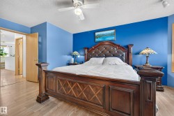 Wood-finish flooring, ceiling fan with integrated lighting, and a light wood-tone door - 