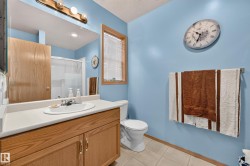 Wood-finish vanity with an integrated sink, broad mirror, and overhead vanity lighting - 