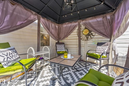 Covered outdoor structure with a solid roof, privacy curtains, and slatted perimeter walls - 1223 Gillespie Crescent Nw, Edmonton, AB 