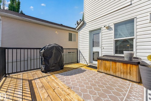 Expansive wooden deck with black metal railings, direct exterior access, and a window with blinds - 1223 Gillespie Crescent Nw, Edmonton, AB 