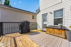 Expansive wooden deck with black metal railings, direct exterior access, and a window with blinds - 