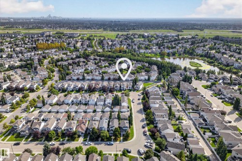 Aerial perspective of a residential neighborhood with a prominent body of water and surrounding green spaces - 1223 Gillespie Crescent Nw, Edmonton, AB 