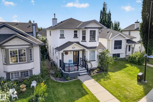 Two-story residence with a covered front porch, bay window, and dark shingle roof - 1223 Gillespie Crescent Nw, Edmonton, AB 