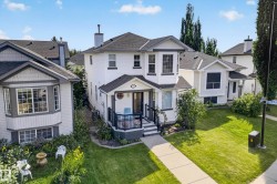Two-story residence with a covered front porch, bay window, and dark shingle roof - 