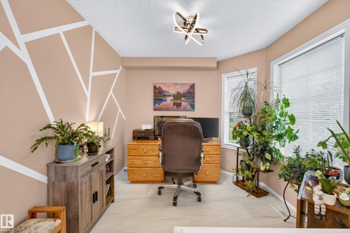 Recessed lighting, contemporary ceiling light fixture, two windows with blinds, wood-finish flooring, and a built-in wood-finish cabinet - 1223 Gillespie Crescent Nw, Edmonton, AB 