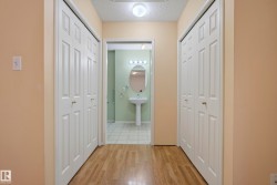 Hallway featuring wood-finish flooring and bi-fold panel doors - 