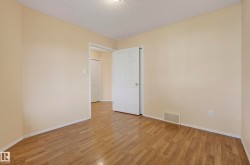 Wood-finish flooring throughout, neutral wall paint, and white trim - 