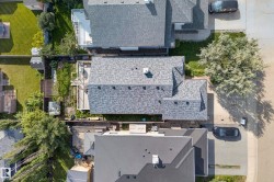 Gabled roofline with asphalt shingles, featuring a chimney and multiple roof planes - 