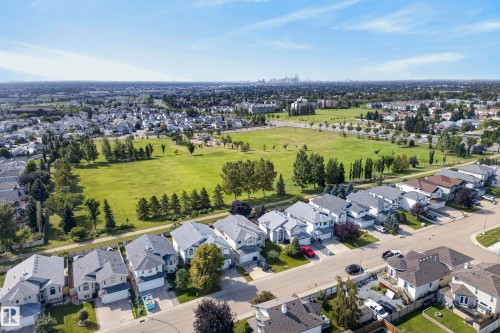 Expansive green spaces and mature trees surround residential areas with varied architectural styles - 15213 49A Street Nw, Edmonton, AB 