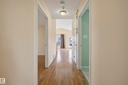 Hallway with wood-finish flooring, neutral wall tones, and recessed ceiling lighting - 