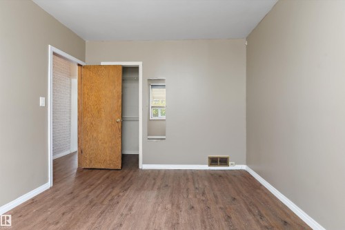 Wood-finish flooring, neutral wall tones, and white trim - 5501 48 Avenue, Wetaskiwin, AB 