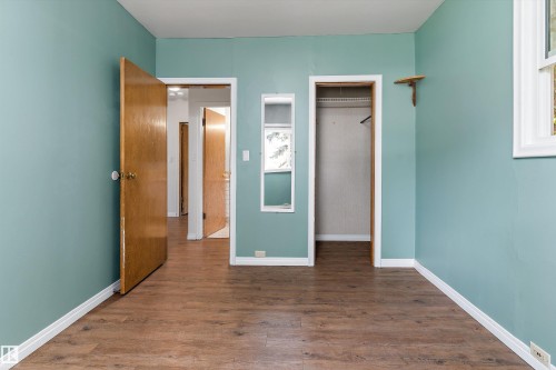 Wood-finish flooring, two panel doors, and a built-in closet with shelving - 5501 48 Avenue, Wetaskiwin, AB 