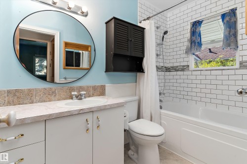 Vanity with integrated sink, white cabinetry, and wall-mounted storage cabinet - 5501 48 Avenue, Wetaskiwin, AB 