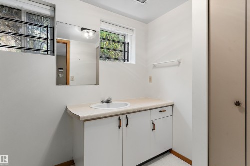 Vanity with an integrated sink, built-in cabinetry, and a wall mirror - 5501 48 Avenue, Wetaskiwin, AB 