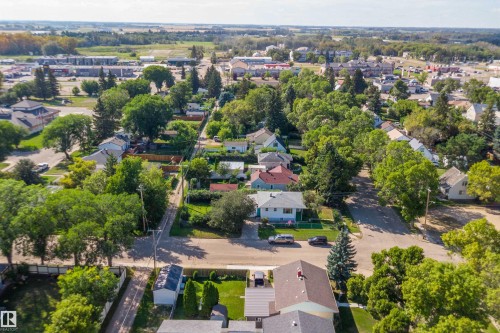 Residential neighborhood with mature tree coverage, paved streets, and a distant commercial area - 5501 48 Avenue, Wetaskiwin, AB 
