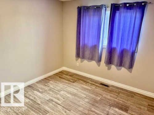 Wood-finish flooring, light-toned wall paint, and white trim - 5133 45A Avenue, Vegreville, AB 