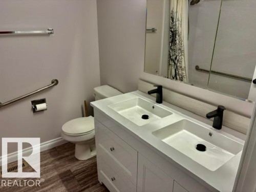 Double vanity with integrated sinks, matte black faucets, and mirrored medicine cabinet - 5133 45A Avenue, Vegreville, AB 
